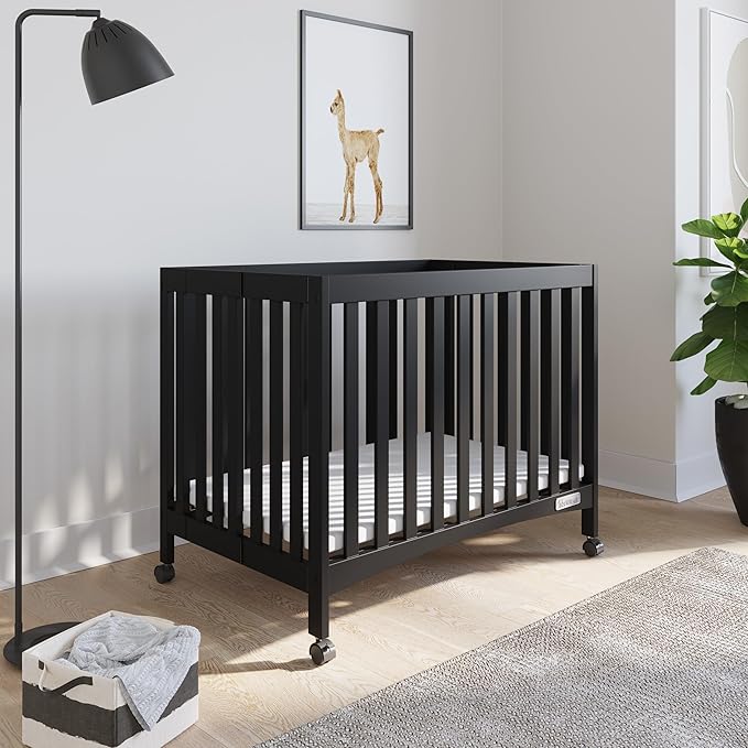 Child Craft London Mini Compact Folding Portable Crib with 2” Crib Mattress and 2 Easy Roll Locking Wheels, Durable Pine Wood Construction (Ebony Black)